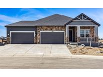 Beautiful two-story home with stone accents, a three car garage, and manicured landscaping at 3884 Freestone Pt, Castle Rock, CO 80108