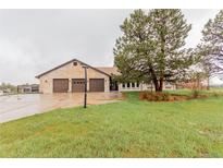 Charming single-story home with a three-car garage and a well-manicured lawn at 1341 Tomichi Dr, Franktown, CO 80116