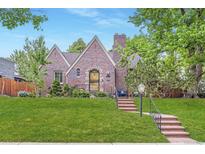 Charming brick home featuring a manicured lawn, brick steps, mature trees, and stylish curb appeal at 926 S Fillmore Way, Denver, CO 80209