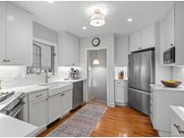 Bright kitchen features white cabinets, stainless steel appliances, and a farmhouse sink at 926 S Fillmore Way, Denver, CO 80209