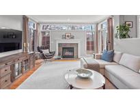 Inviting living room with a fireplace, large windows, hardwood floors, and comfortable seating at 926 S Fillmore Way, Denver, CO 80209