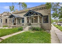 Charming stone-clad home with covered front porch and manicured lawn offers great curb appeal at 194 S Emerson St, Denver, CO 80209
