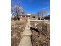 Charming red brick home featuring a well-maintained front yard, inviting walkway, and 'For Sale' sign at 10866 Pearl St, Northglenn, CO 80233