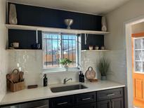Bright kitchen featuring a stainless steel sink, white countertops, and subway tile backsplash at 1521 Yosemite St, Denver, CO 80220
