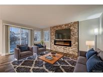 Inviting living room with a stone accent wall and fireplace, perfect for relaxation and entertaining guests at 2221 Mattive Pl, Brighton, CO 80601