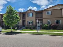 Tan two-story townhome with front yard and landscaping at 1211 Bistre St, Longmont, CO 80501