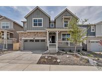 Charming two-story home showcasing stone accents, neutral paint, a two-car garage, and a covered front porch at 2089 S Fultondale Way, Aurora, CO 80018