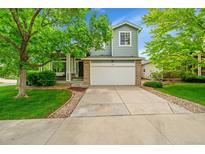 Charming two-story home with a well-maintained lawn, driveway, and mature trees at 10571 Garfield St, Thornton, CO 80233