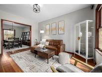 Comfortable living room featuring hardwood floors, a modern light fixture, and stylish furnishings at 2023 E 20Th Ave, Denver, CO 80205