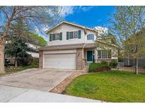 Charming two-story home featuring a two car garage, mature landscaping, and a beautiful lawn at 10517 Madison St, Thornton, CO 80233