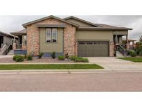 Charming home with a stone and siding exterior, two-car garage, and meticulously landscaped front yard at 7029 Sagerock St, Castle Pines, CO 80108