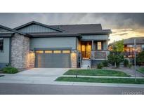 Charming home featuring stone accents, a two-car garage, and well-maintained landscaping at 7029 Sagerock St, Castle Pines, CO 80108