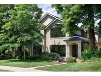 Charming two-story home with stucco exterior, lush landscaping, and mature trees at 355 Steele St, Denver, CO 80206