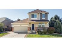 Two-story house with a brick facade, attached garage, and landscaped front yard at 11611 Leyden St, Thornton, CO 80233