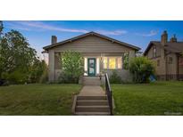 Charming craftsman-style bungalow with a welcoming front porch and well-maintained lawn at dusk at 2703 N Milwaukee St, Denver, CO 80205