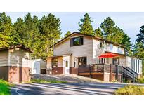 Charming two-story home with a deck and lush trees, offering a serene and private setting at 200 The Lane Rd, Golden, CO 80403