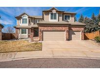 Charming two-story home featuring a brick facade, bay windows, and a spacious two-car garage with a wide driveway at 15407 E Crestline Pl, Centennial, CO 80015