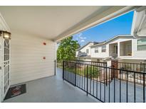 Spacious balcony featuring black metal railings and partial views of neighboring buildings and lush greenery at 1697 S Cole St # B5, Lakewood, CO 80228