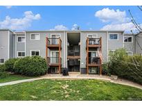Apartment building with balconies, green lawn, bushes, and an American flag flying at 16359 W 10Th Ave # Yy3, Golden, CO 80401