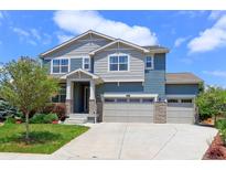 Charming two-story home featuring a three-car garage, landscaped yard, and a welcoming entrance at 2474 Ravenswood Ct, Longmont, CO 80504