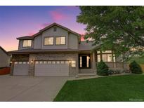 Charming two-story home with a well-manicured lawn and brick accents, enhanced by a lovely dusk sky at 14910 Williams St, Thornton, CO 80602