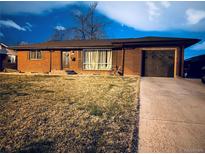 Well-kept single-story brick home with attached garage and manicured front lawn at 413 Jamaica St, Aurora, CO 80010