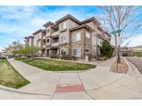 Attractive three-story condo building with stone accents, balconies, and well-maintained landscaping on a sunny day at 9318 Las Ramblas Ct # R, Parker, CO 80134