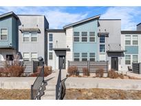 Contemporary townhome featuring a modern facade, gray horizontal fence and concrete steps leading to the entrance at 16261 Bolling Dr, Denver, CO 80239