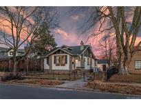 Charming home featuring a landscaped yard, wrought iron fence and pleasant curb appeal at 2620 Bellaire St, Denver, CO 80207