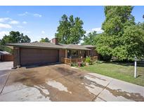 Charming brick home featuring a spacious front yard, an attached two-car garage and a covered porch at 8178 W 64Th Ave, Arvada, CO 80004
