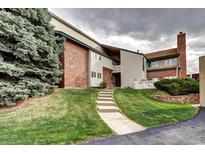 Attractive townhouse exterior features a brick facade and a well-maintained lawn with a concrete stairway at 7877 S University Way, Centennial, CO 80122