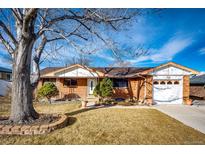 Charming brick home featuring a well-manicured lawn and attached garage at 9241 Knox Ct, Westminster, CO 80031