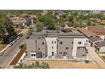 New construction modern townhomes with gray and white exteriors, and a view of the city skyline at 1372 Lowell Blvd # 4, Denver, CO 80204