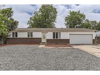 Charming single-story home featuring a brick facade, well-maintained lawn, and an attached garage at 16293 E Brown Pl, Aurora, CO 80013