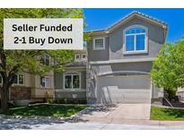 Charming two-story home with a neutral-toned exterior, arched window, attached garage, and well-maintained lawn at 11969 E Lake Cir, Greenwood Village, CO 80111