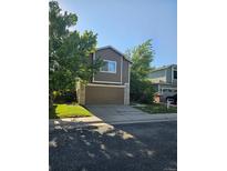 Charming two-story home featuring a well-maintained lawn and attached two car garage at 12738 E Wyoming Cir, Aurora, CO 80012