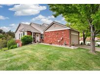 Charming brick home with a well-manicured front yard and mature landscaping at 9441 Southern Hills Cir, Lone Tree, CO 80124