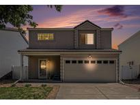 Charming two-story home with a well-maintained lawn and two-car garage against a beautiful evening sky at 4076 Andes Way, Denver, CO 80249