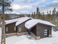 Modern home featuring wood siding, stone accents, and an attached garage in a snowy mountain setting at 578 American Way, Breckenridge, CO 80424