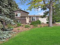 Charming two-story home with a lush green lawn and mature trees at 9236 W Euclid Ave, Littleton, CO 80123