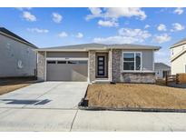 Charming single-story home featuring stone accents, a two-car garage, and a well-lit entrance at 6974 E 126Th Dr, Thornton, CO 80602