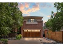 Stunning brick home with a statement garage door and beautiful landscaping with mature trees at 350 Holly St, Denver, CO 80220