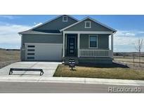 Charming single-story home with a welcoming front porch and a well-manicured lawn on a sunny day at 42986 Colonial Trl, Elizabeth, CO 80107