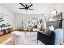 Bright living room features hardwood floors, a modern ceiling fan, and stylish, comfortable furniture at 1445 Ash St, Denver, CO 80220