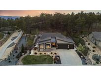 A beautifully landscaped home featuring a three car garage, and a wooded lot with rock features at 16244 Thunder Cat Way, Monument, CO 80132