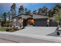 Charming single-story home featuring stone accents, a three-car garage, and a well-maintained front yard at 16244 Thunder Cat Way, Monument, CO 80132