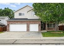 Charming two-story home with a brick facade, two-car garage, and well-maintained lawn at 2078 Goldfinch Ct, Longmont, CO 80503