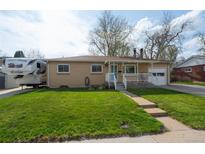 Charming brick home with well-manicured lawn and a covered front porch at 6705 Nelson St, Arvada, CO 80004