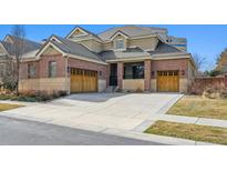 Charming two-story home features a brick exterior, tile roof, and attached two-car garage at 34 Sommerset Cir, Englewood, CO 80111