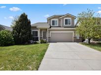 Inviting two-story home with a well-manicured lawn and a spacious driveway leading to a two-car garage at 4713 S Ireland St, Aurora, CO 80015